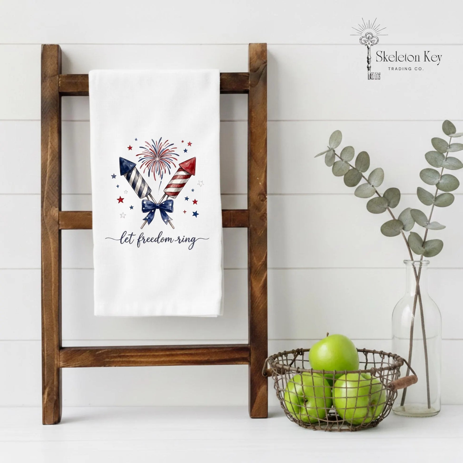 Fourth of July kitchen towel displayed on wooden ladder with patriotic fireworks design and Americana decor