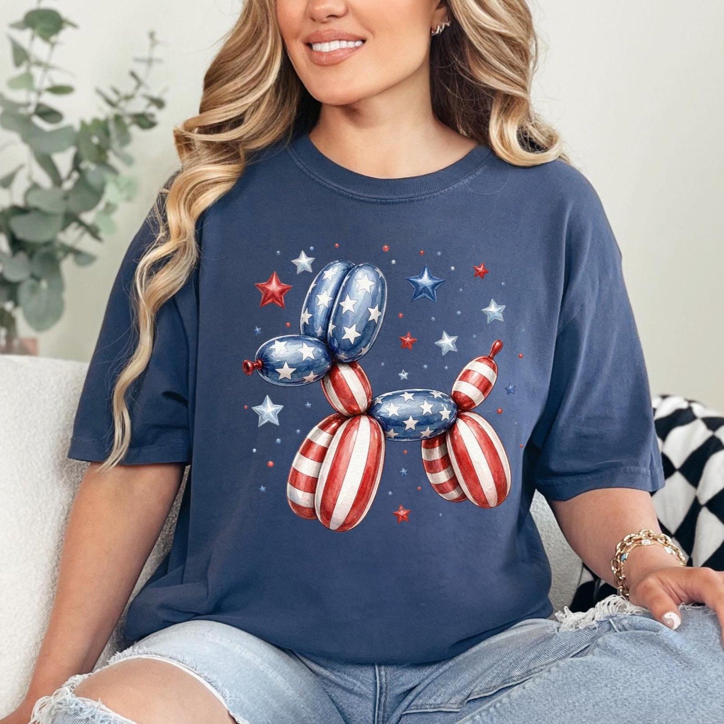 May include: Navy blue t-shirt featuring a balloon dog design in red, white, and blue, with star accents. The design is reminiscent of the American flag, perfect for patriotic celebrations.