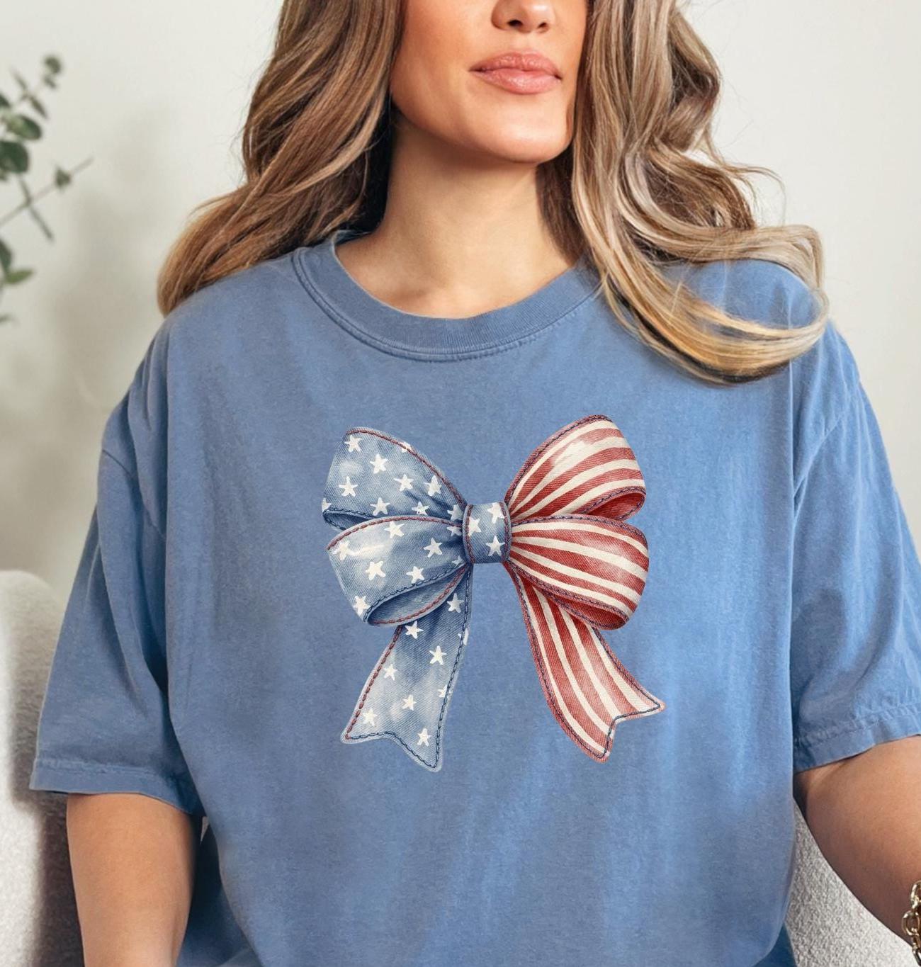 Patriotic coquette bow t-shirt featuring American flag stars and stripes bow graphic on blue comfort color shirt