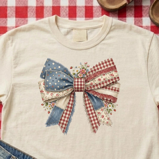 Beige sweatshirt with a decorative bow on a red and white checkered tablecloth.