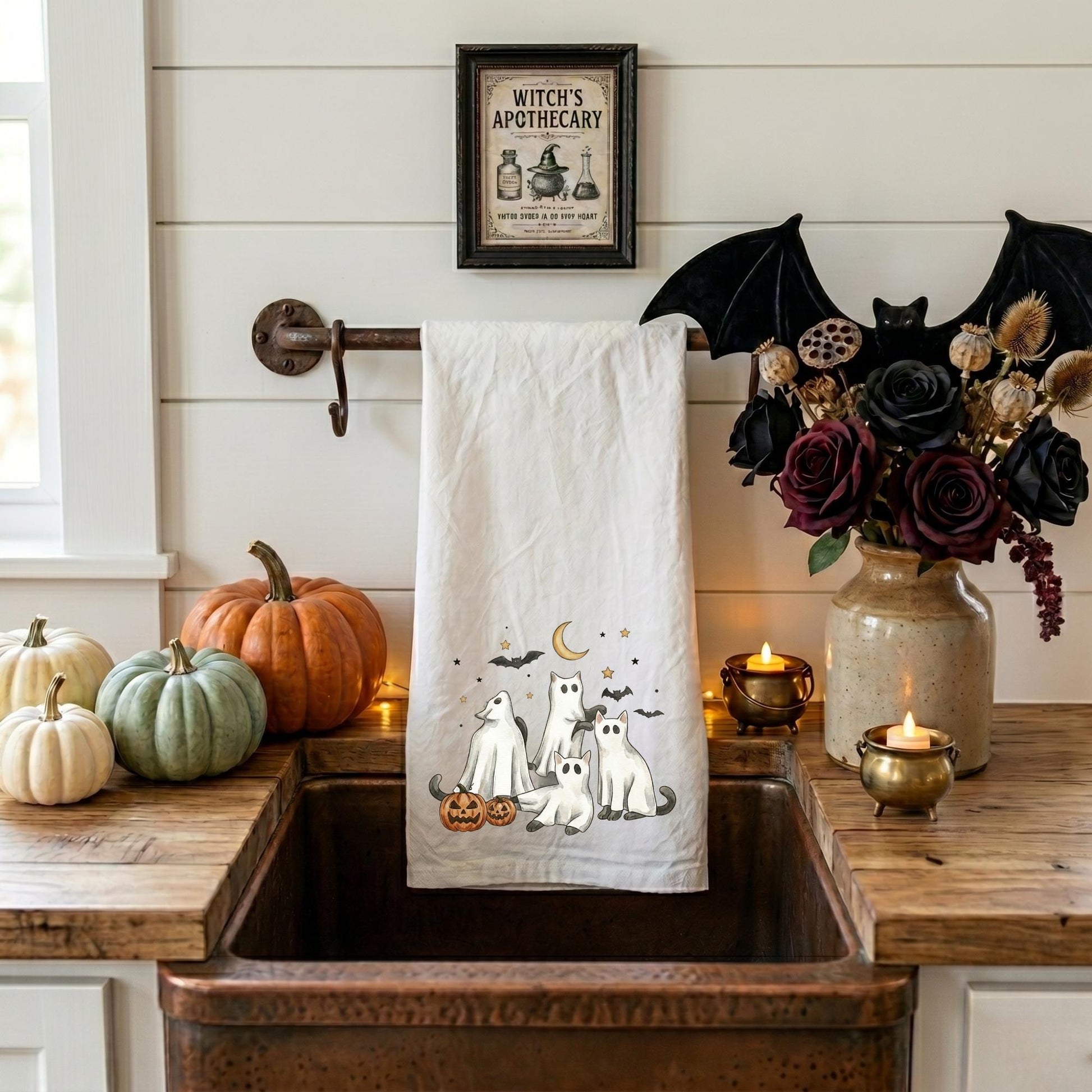 Decorative Halloween kitchen towel featuring ghost cats and whimsical spooky season artwork in an apothecary kitchen
