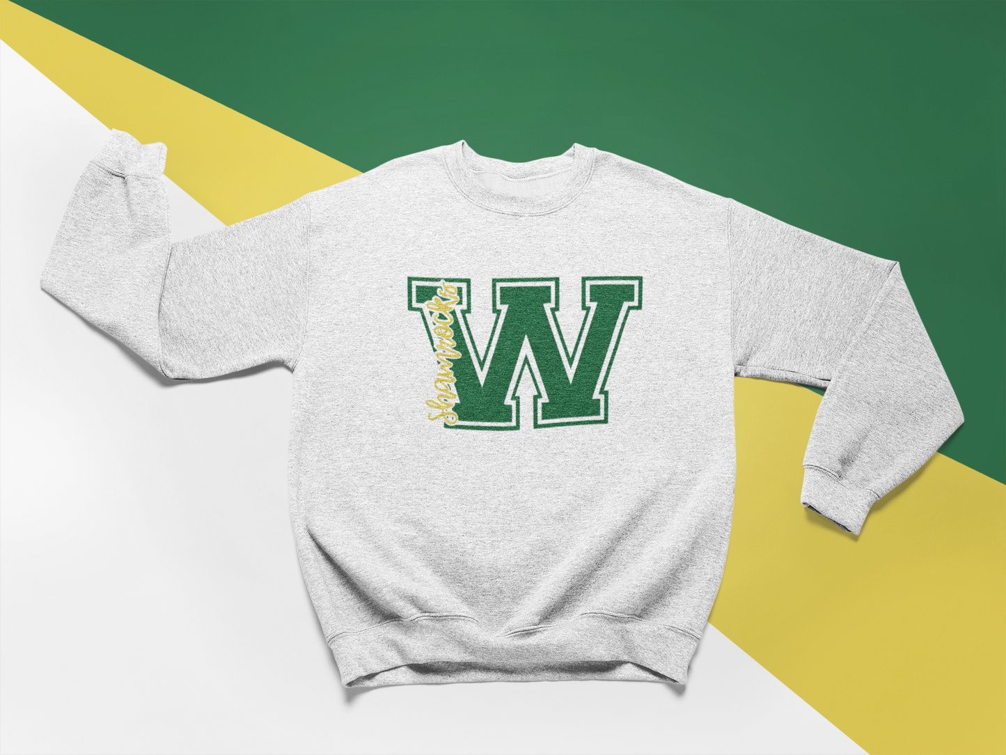 Flat lay of an athletic grey crewneck sweatshirt with a green Westfield Shamrocks varsity ‘W’ design and yellow script lettering.
